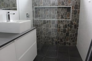 One design tip is if you can continue the stone wall onto the outside that’s visible through a window to help blur the lines between inside and out this will create the illusion of a larger space.